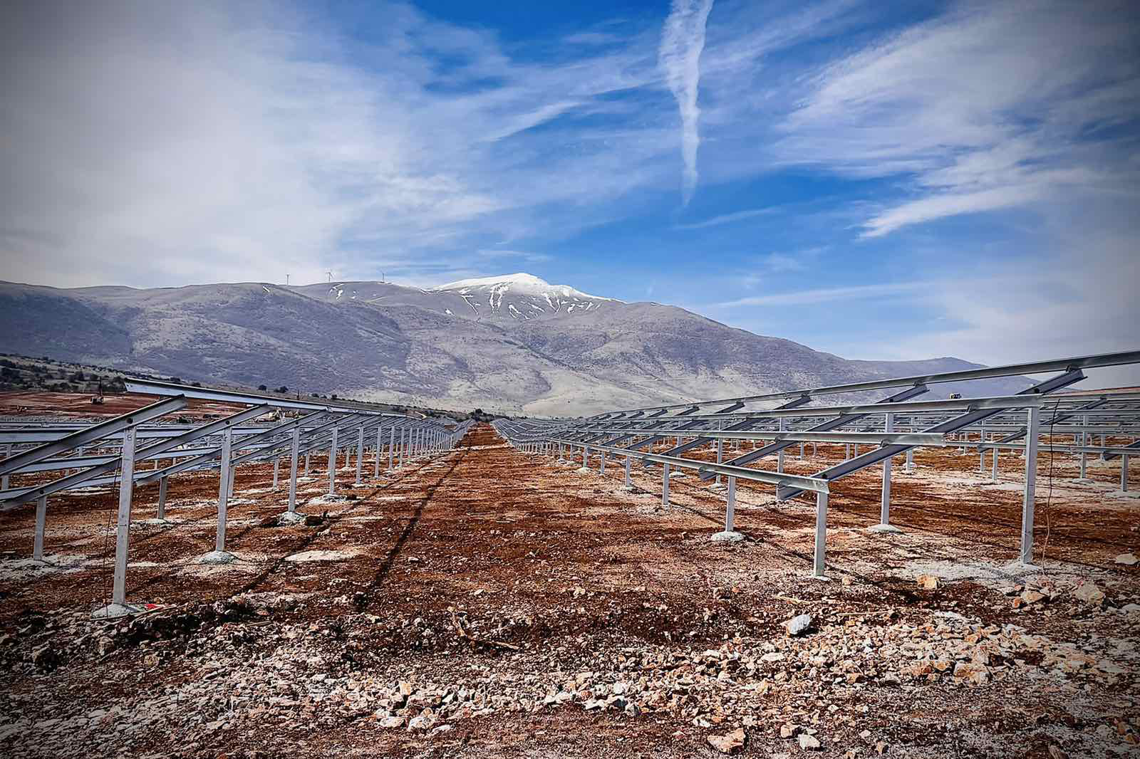 a fenced off area with a mountain in the background